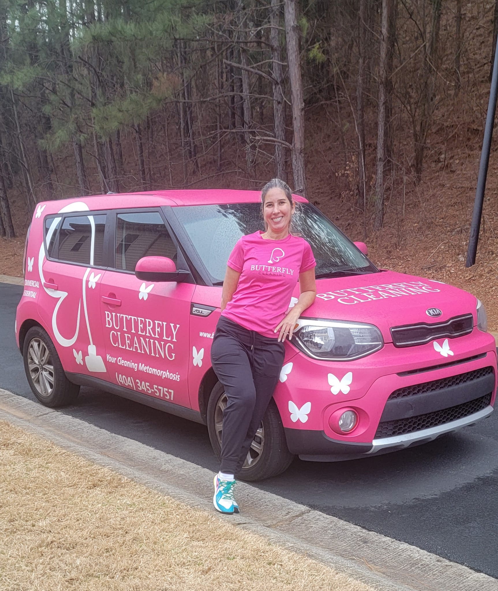 Lilian, founder of Butterfly Cleaning, beside the pink Butterfly Cleaning car in Atlanta
